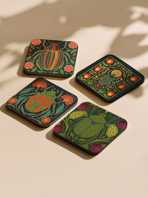 Set of 4 square Dark Academia Scarab Beetle Coasters, featuring detailed Gothic Botanical insect art prints in deep jewel tones. The hardboard coasters have a glossy finish and protective cork base. Premium Entomology Decor.